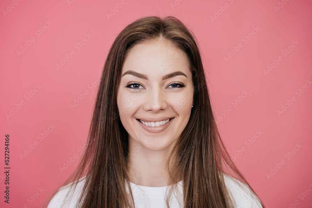 Close up portrait of cheerful caucasian young woman broad smiling looking at camera against pink studio background. Happy people. Happy model with loose hair satisfied, toothy smiling.. Close up portrait of cheerful caucasian young woman broad smiling looking at camera against pink studio background. Happy people. Happy model with loose hair satisfied, toothy smiling..