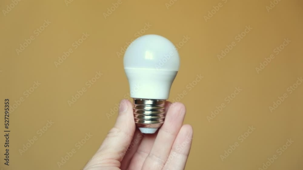 Light bulb in hand on a yellow background. light and electricity concept Light bulb in hand on a yellow background. light and electricity concept
