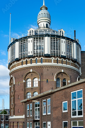 Industrial view of water tower and basin in Rotterdam, The Netherlands, on a sunny day against a blue sky now repurposed as a residential building