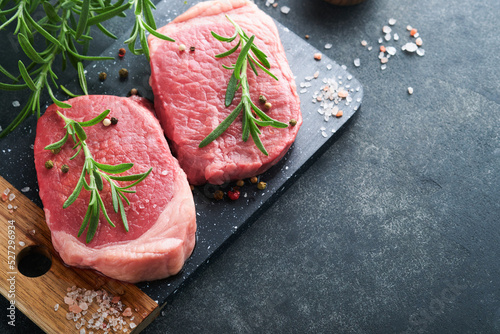 Steaks. Fresh Filet mignon Steaks with spices rosemary and pepper on black marble board on gray background. Top view. Mock up.