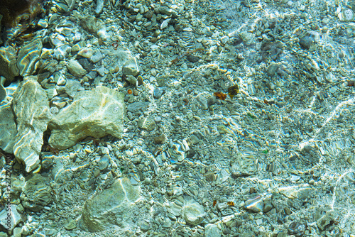 Blurred abstract marine background  stones underwater. Clear sea water covers the rocks.