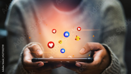 Foto Happy woman looking on smartphone watching social and online entertainment, shopping, paying money in the digital world with fun and happiness emoticons, Social media and digital online concepts