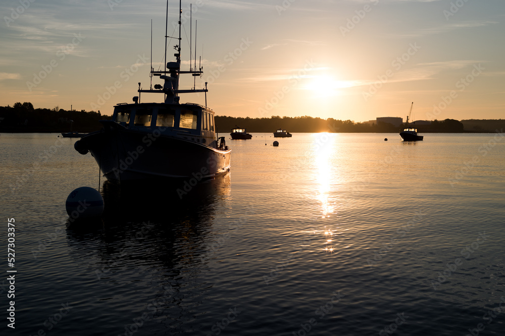 Moored boats at dawn light in Searsport Maine with the sun rising in the background. Moored boats at dawn light in Searsport Maine with the sun rising in the background.