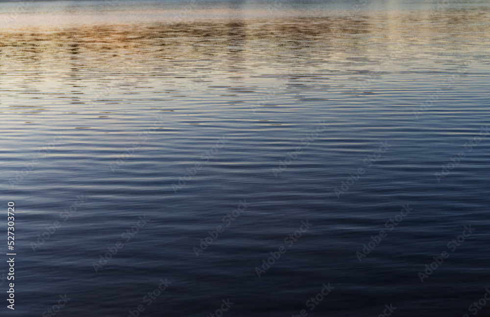Reflection of sunrise on the surface of a lake in Maine with a slight breeze. Reflection of sunrise on the surface of a lake in Maine with a slight breeze.