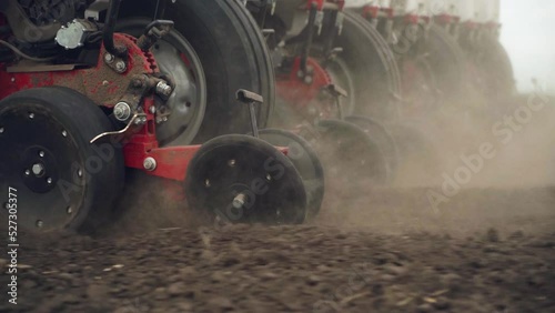 sowing the field with corn grains. tractor works the field with a seeder. close-up