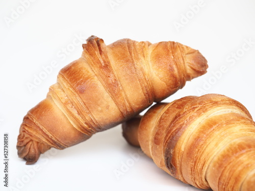 Golden brown baked small homemade French butter croissant on white background