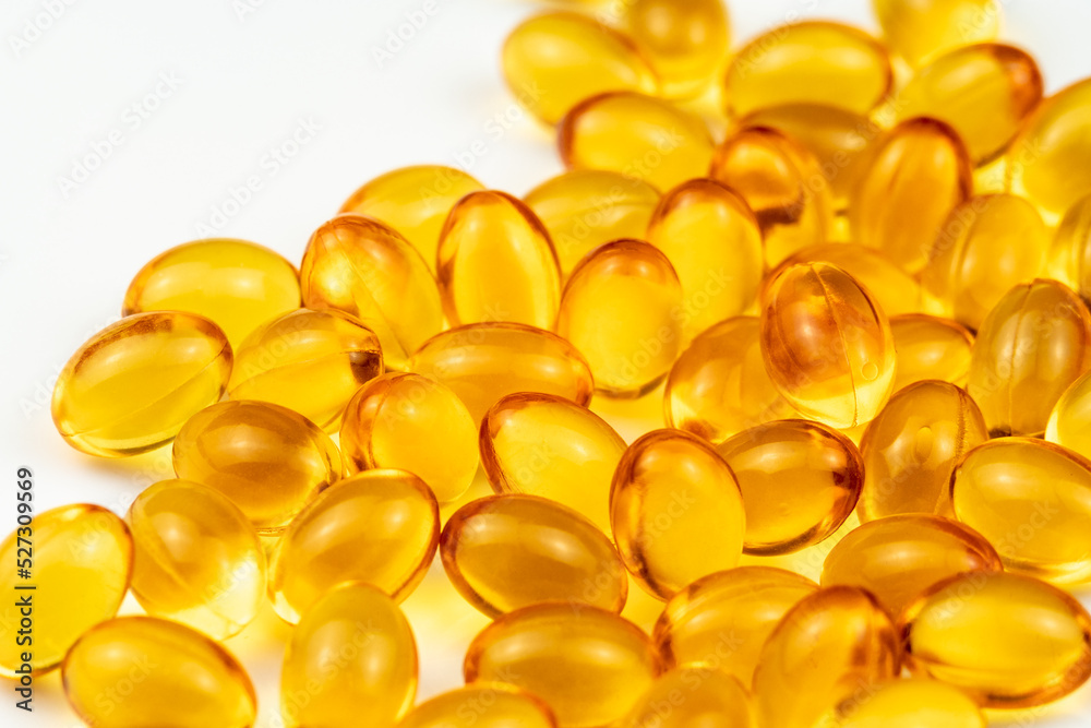 Fish Oil Capsules on a White Surface. Healthy Background and Medicine Concept. Omega 3 Natural Fat in Healthy Lifestyle and Sport Dieting. Yellow Pills with Cod Liver Oil Medicines Fish Oil Capsules on a White Surface. Healthy Background and Medicine Concept. Omega 3 Natural Fat in Healthy Lifestyle and Sport Dieting. Yellow Pills with Cod Liver Oil Medicines