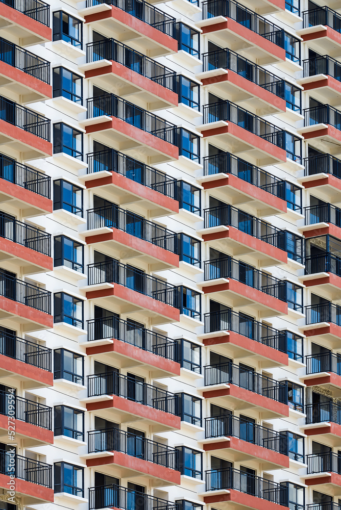 Close up of regular and neat balcony windows on a residential building in the city