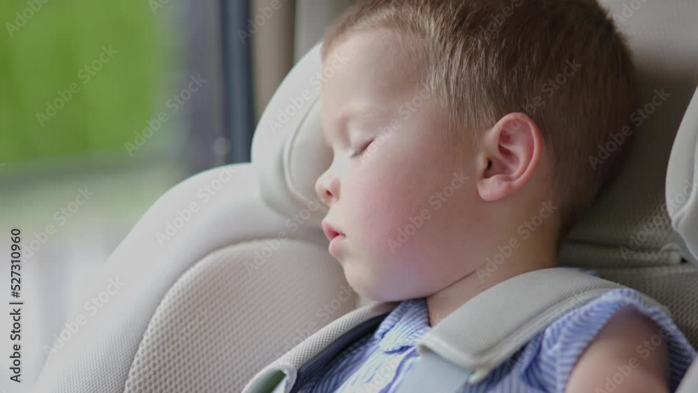 Stockvideo sweat dreams baby sleeping in car seat inside vehicle, face