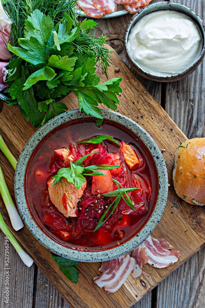 National dish of Ukrainian cuisine borscht with vegetables, turkey meat, herbs, sour cream and traditional bread (bun with garlic and dill, pampushka) with bacon (pork). Cultural heritage. National dish of Ukrainian cuisine borscht with vegetables, turkey meat, herbs, sour cream and traditional bread (bun with garlic and dill, pampushka) with bacon (pork). Cultural heritage.