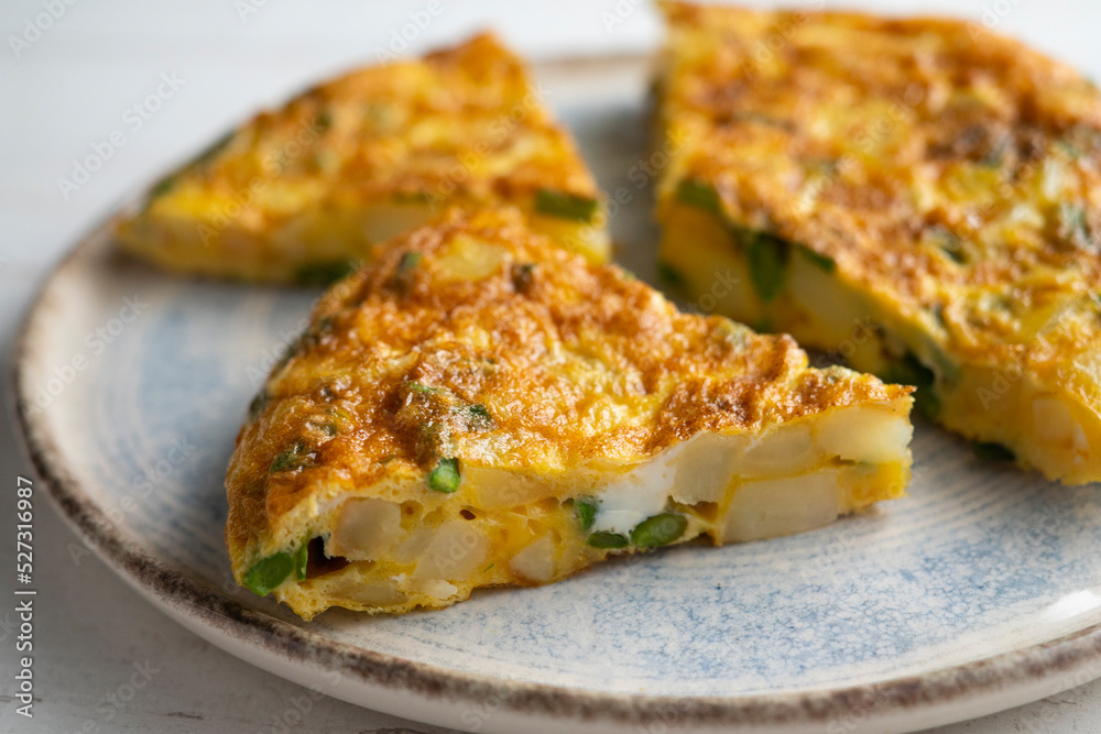 Spanish potato omelette with green asparagus. Traditional Spanish tapa recipe.