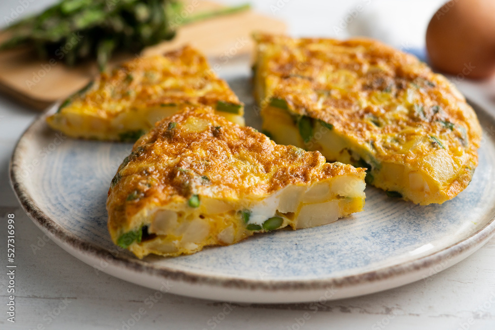 Spanish potato omelette with green asparagus. Traditional Spanish tapa recipe.