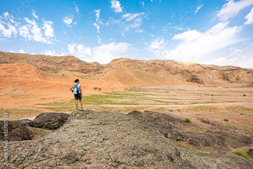Woman with backpack admiring the view from the top of a hill in Al Faya Mountains, Sharjah, UAE