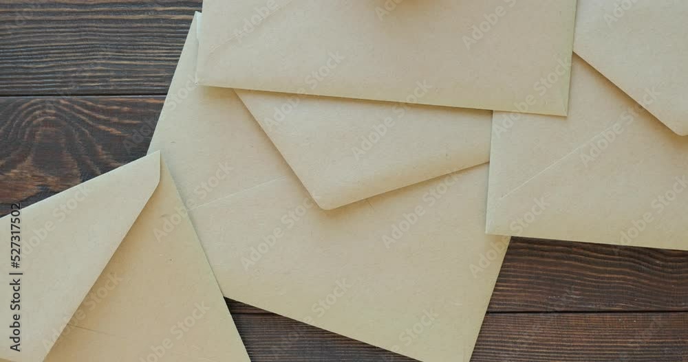 Craft envelopes for letters on a wooden brown table. 4K stop motion animation