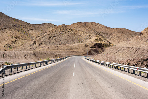 Empty road going thru arid mountains in the Sultanate of Oman, Middle East, Arabian Peninsula  photo