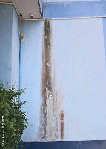 Rain stains on the wall Moss stains outside the building, blue background, leaking wall