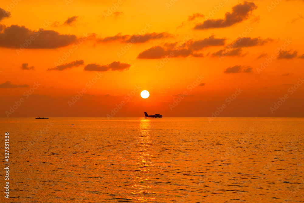Sunset on Maldives island. Beautiful sky and ocean and beach with palms background for summer vacation holiday and travel concept.