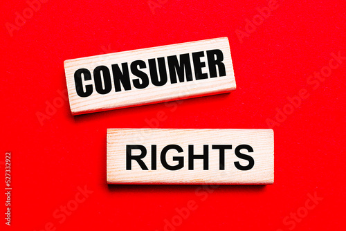 On a bright red background, there are two light wooden blocks with the text CONSUMER RIGHTS