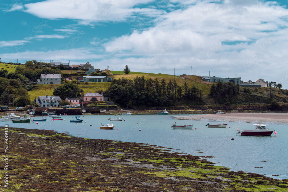 The coast of Ireland. Small fishing boats are anchored in Clonakilty Bay at low tide. Picturesque seascape. European fishing village on the shore.