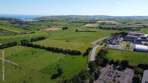 Clonakilty Agricultural College among fields on a sunny summer day, buildings on green grass field, top view.