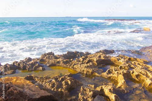 Big waves of the Mediterranean sea roll in at the rocky Beach of the western side of Arwad (Arados) in Syria, on a cold yet sunny winter morning. - Image