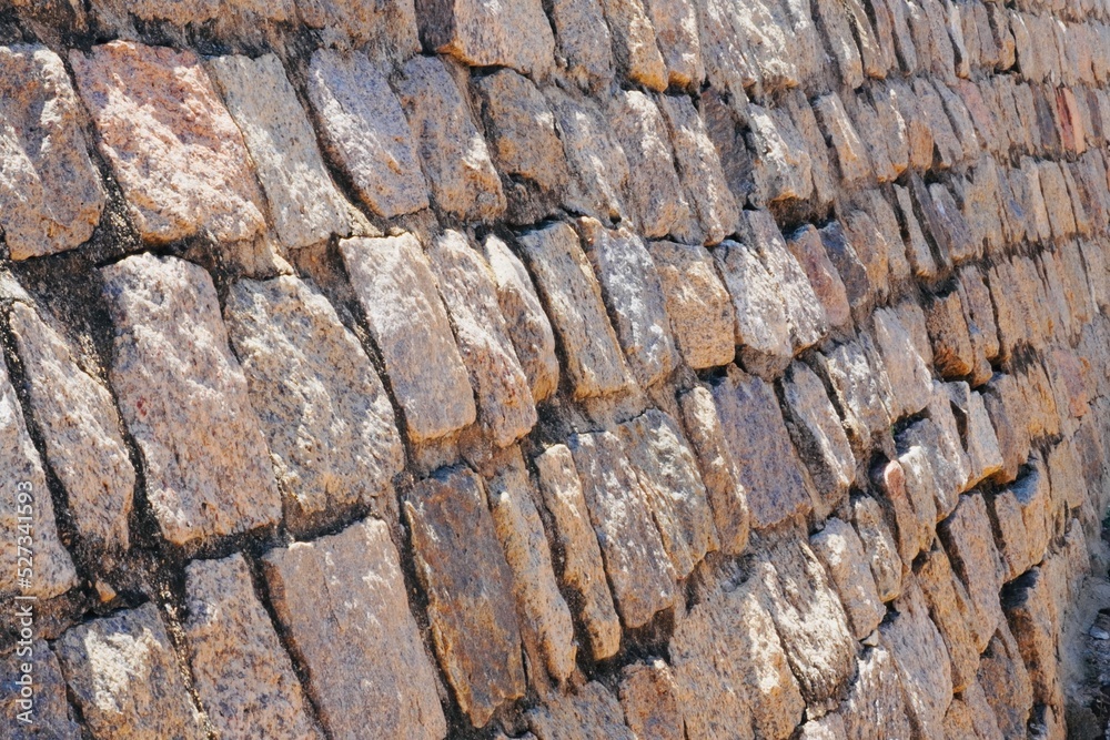 Stone wall texture. Stone arrangement in pattern. Abandoned stone wall construction in the historical heritage site at shore temple complex at Mahabalipuram, Tamilnadu, India. Stone wall texture. Stone arrangement in pattern. Abandoned stone wall construction in the historical heritage site at shore temple complex at Mahabalipuram, Tamilnadu, India.