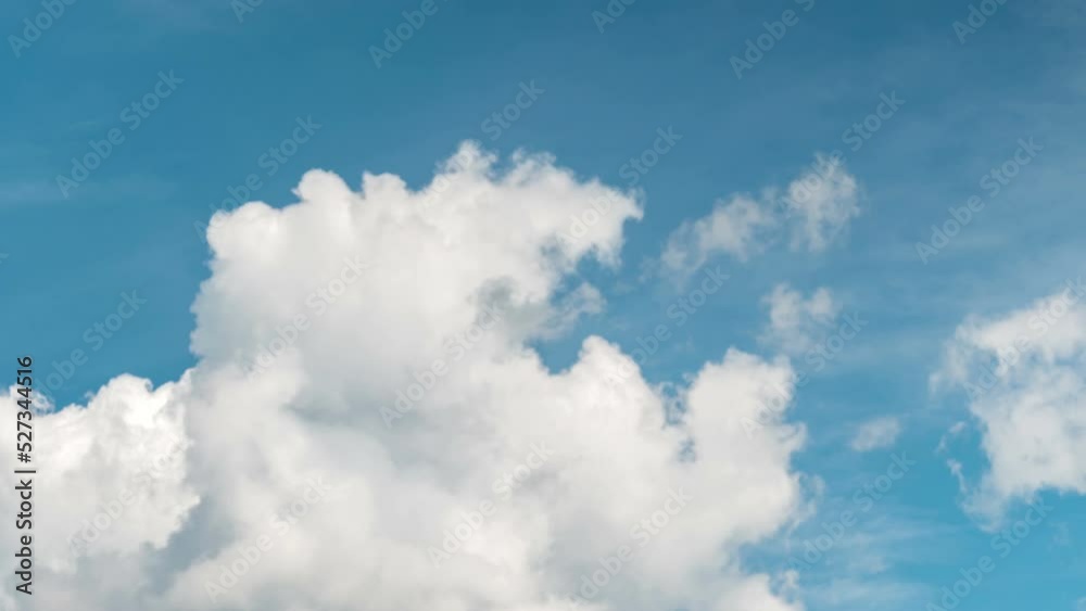 fluffy clouds on a clear bright blue sky. Overall plan fluffy clouds on a clear bright blue sky. Overall plan
