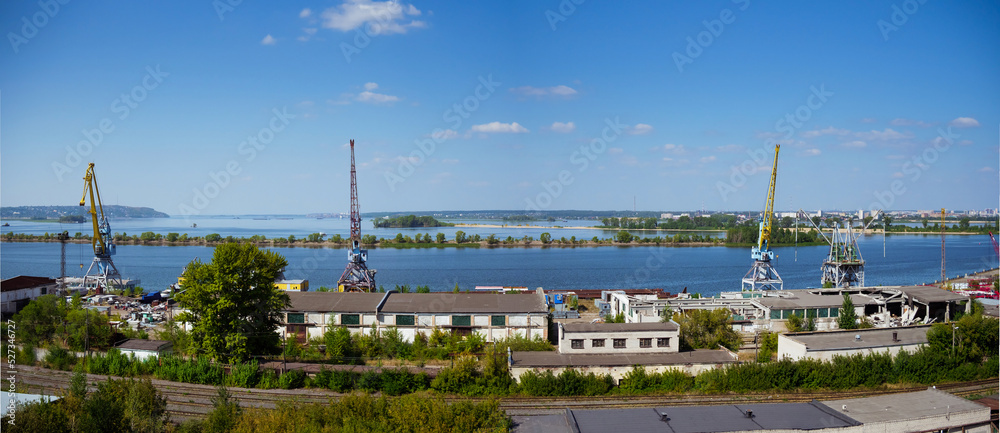 Port cranes on the Volga River, Russia. Freight river transport infrastructure. 