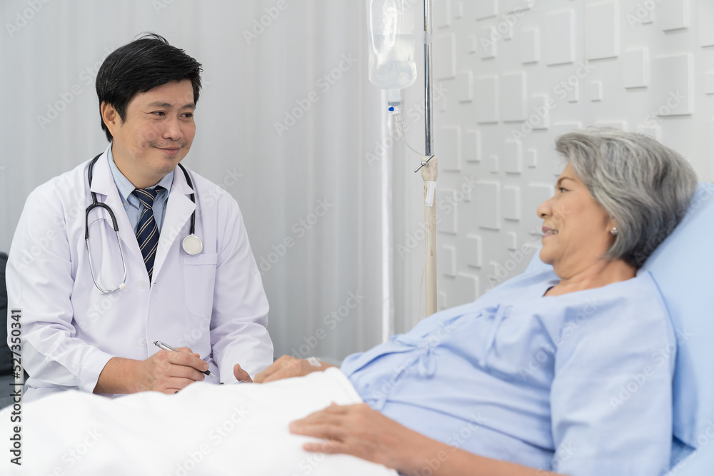 Male doctor visit elderly patient asian woman on bed at the hospital. People and health care concept Male doctor visit elderly patient asian woman on bed at the hospital. People and health care concept