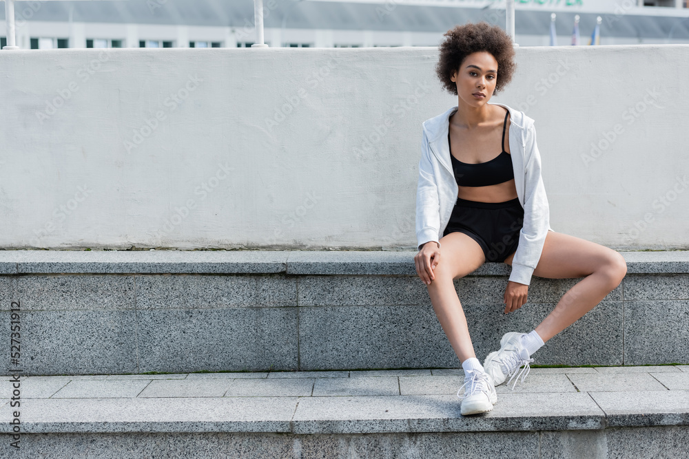 African american sportswoman in sports jacket looking at camera on stadium. African american sportswoman in sports jacket looking at camera on stadium.