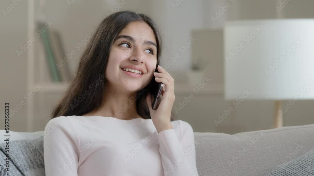 Arabian girl happy client talking mobile phone at home friendly chatting gossiping with friend by smartphone sharing news positive feedback calling in delivery making order distant cell communication Arabian girl happy client talking mobile phone at home friendly chatting gossiping with friend by smartphone sharing news positive feedback calling in delivery making order distant cell communication
