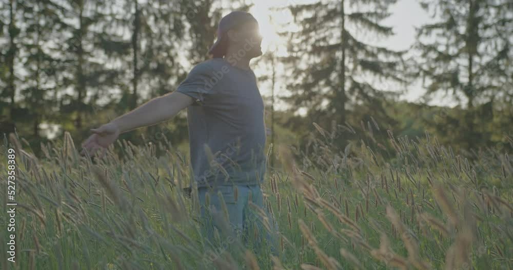 A handsome guy jumps and joyfully spins on field with tall grass in slow motion. A handsome guy jumps and joyfully spins on field with tall grass in slow motion.