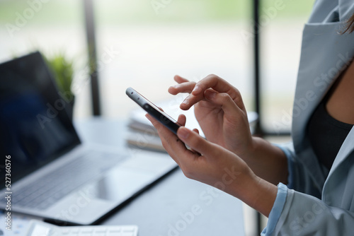 Close-up of a woman using a smartphone to work on various application including mobile transaction to send messages  LINE  and various business information sent via social media.