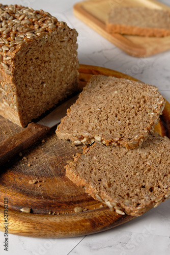 Close up view of a whole spelt bread on a wooden cutting board