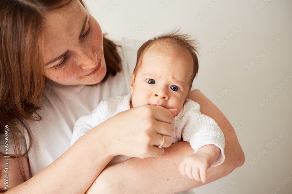 Mother holding her newborn baby. Home portrait of newborn baby and mother. Enjoying time together Mother holding her newborn baby. Home portrait of newborn baby and mother. Enjoying time together