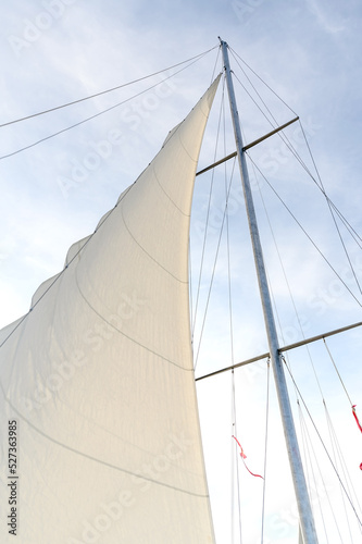 White sails in the blue sky. Travel by boat on the sea.