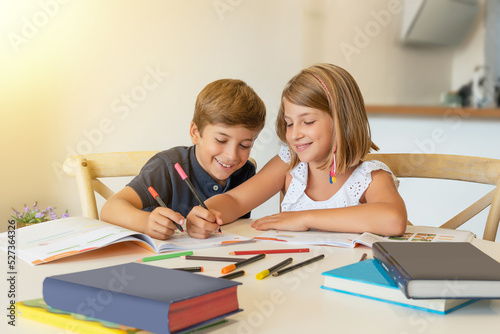 Smiling children drawing and studying at home. Kids doing homework in the classroom and helping each other. Back to school. Fellowship and learning