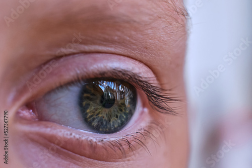 Close-up of the child's eye. Side view. Macro shot of the left eye. The boy looks into the far distance