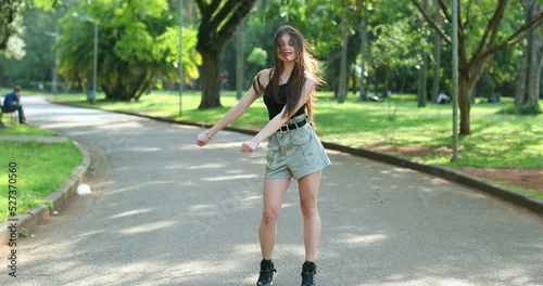 Young Hispanic woman dancing floss in park outside relaxed and celebration