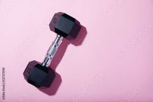 Dumbbell on pink background photo