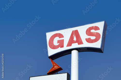 Low angle view of vintage gas station sign against sky