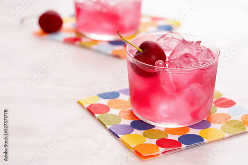Red mocktail with cherry on colorful napkin photo