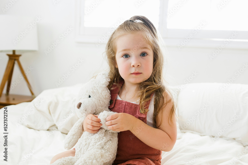 Portrait of girl (2-3) sitting on bed with teddy bear Portrait of girl (2-3) sitting on bed with teddy bear
