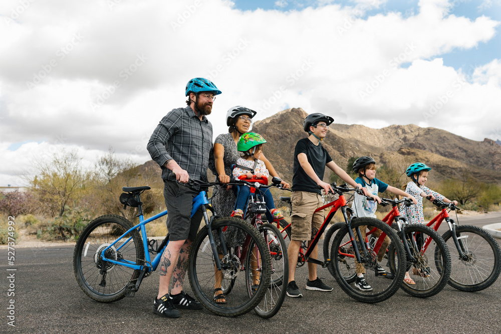 Family with children (2-3, 8-9, 14-15) biking together Family with children (2-3, 8-9, 14-15) biking together