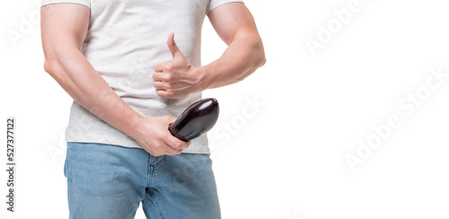Guy crop view giving thumb holding eggplant at crotch level imitating erect penis, copy space photo