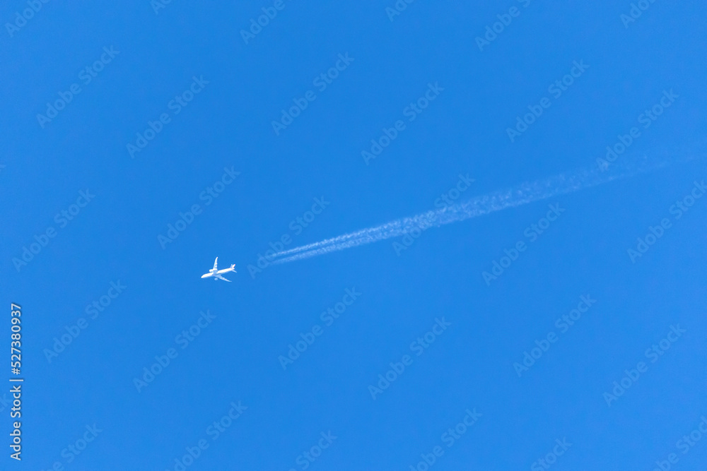 A plane crossing the blue sky leaving a white trail. A plane crossing the blue sky leaving a white trail.
