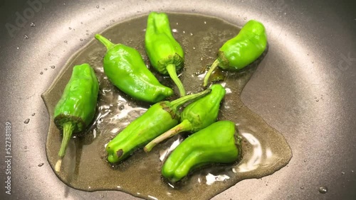 Closeup, padron peppers being grilled over a low heat, as a typical dish of Spanish cuisine. 4k resolution