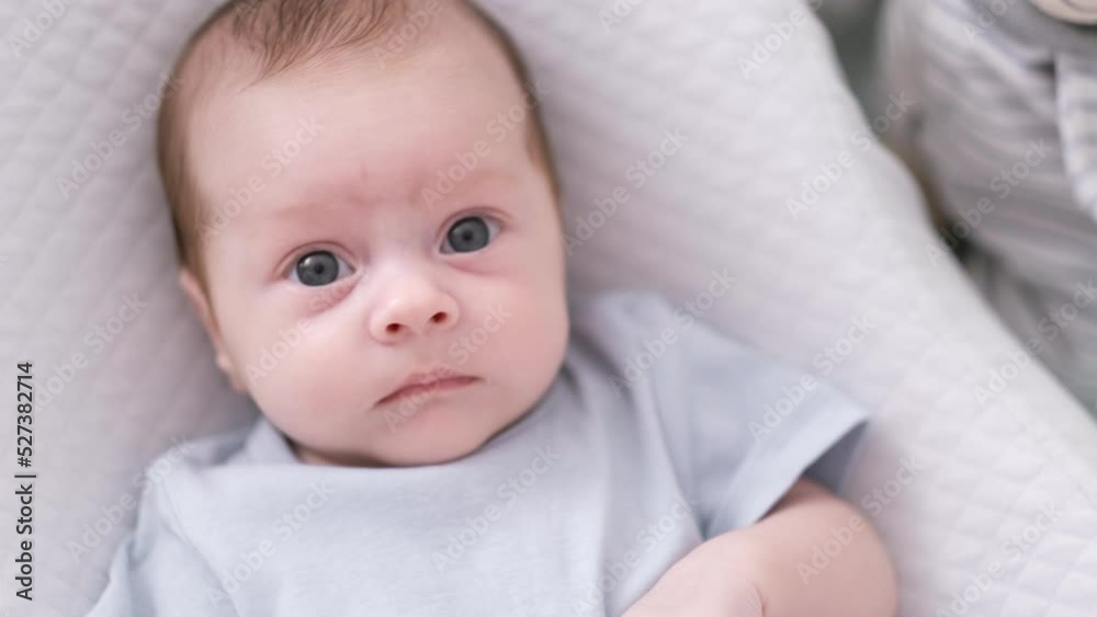 Portrait newborn baby boy lying in nursery cocoon with blue clothes on bed in bedroom at home, happy baby morning Portrait newborn baby boy lying in nursery cocoon with blue clothes on bed in bedroom at home, happy baby morning