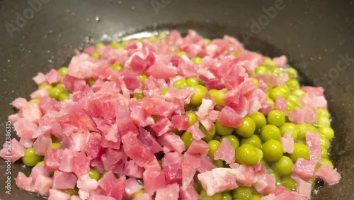 Closeup, peas with serrano ham, simmering on the grill, as a typical healthy dish in spain. 4k resolution