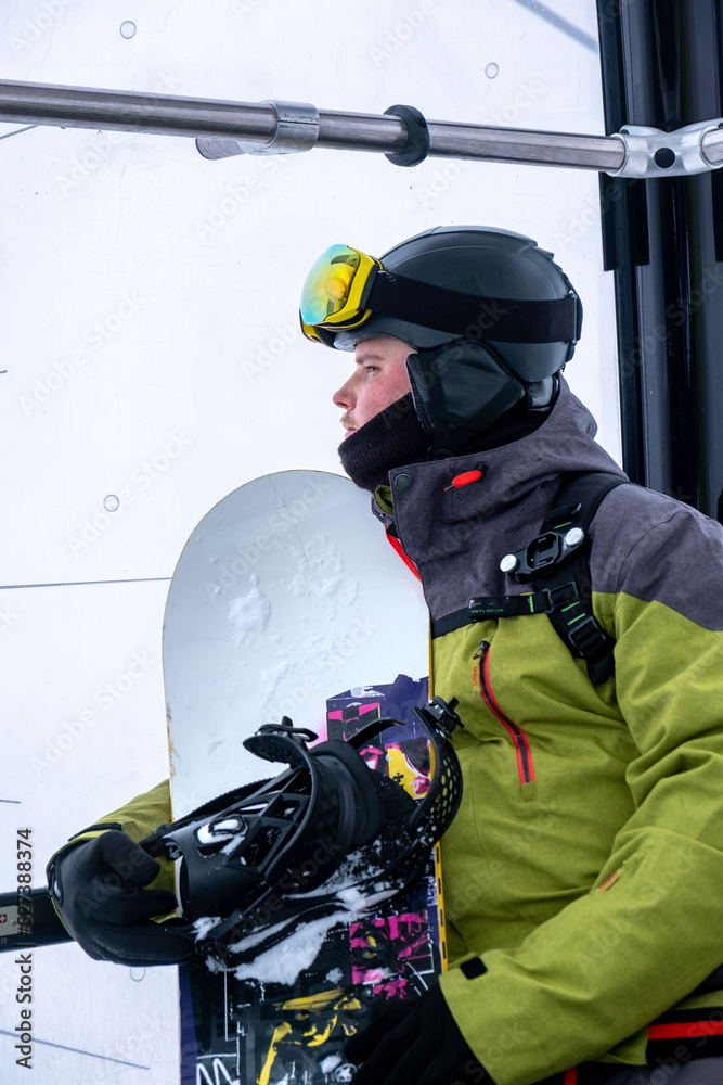 Naklejka premium man snowboarder portrait in ski lift cabin
